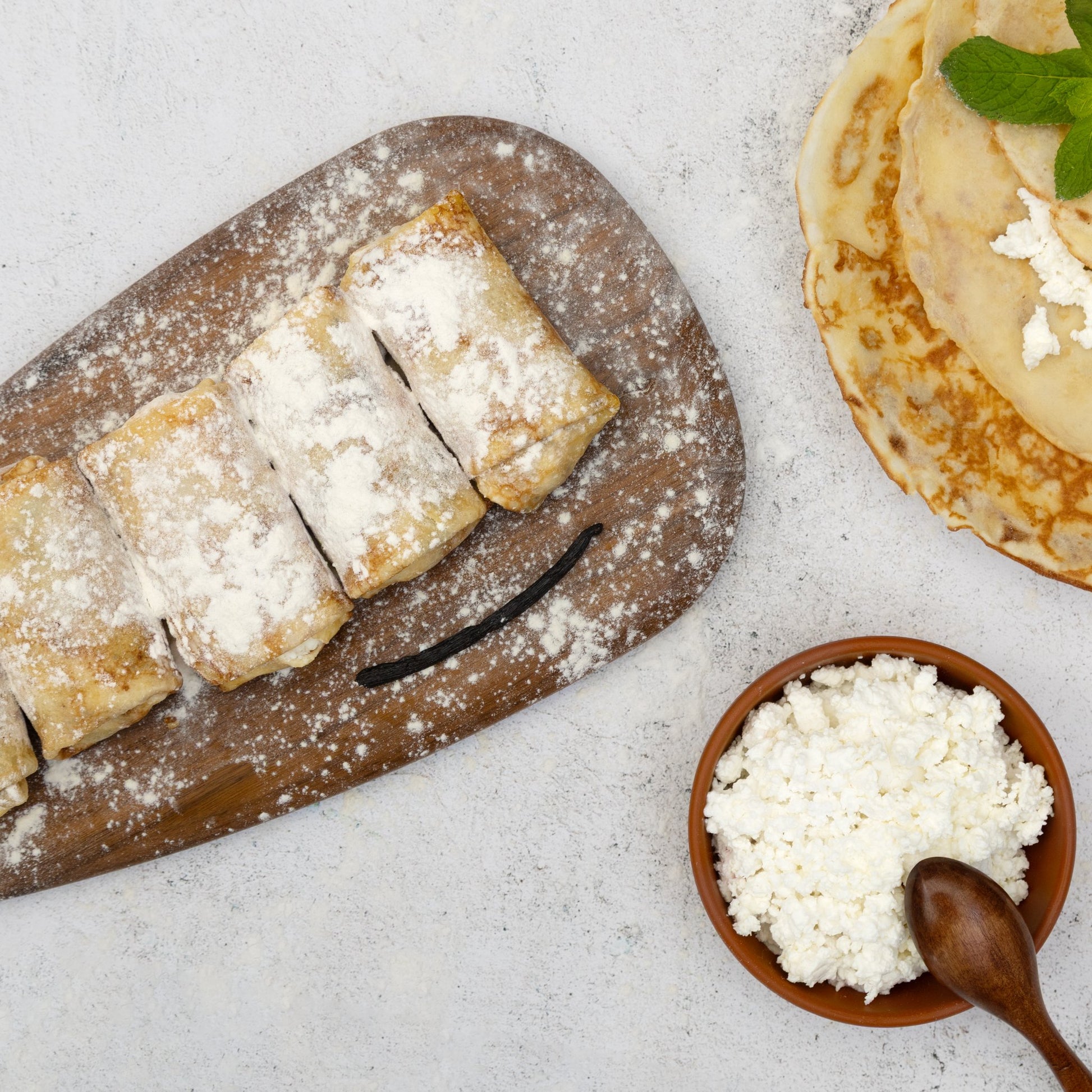 Uncooked sweet cheese crepes dusted with flour and cottage cheese—traditional twarog filling prep scene.