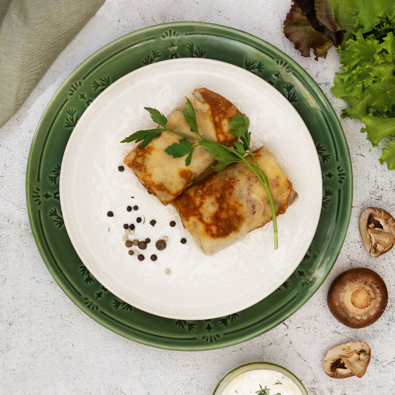 Frozen chicken and mushroom crepes served on plate with parsley – authentic Eastern European ready meal.
