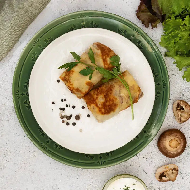 Frozen chicken and mushroom crepes served on plate with parsley – authentic Eastern European ready meal.